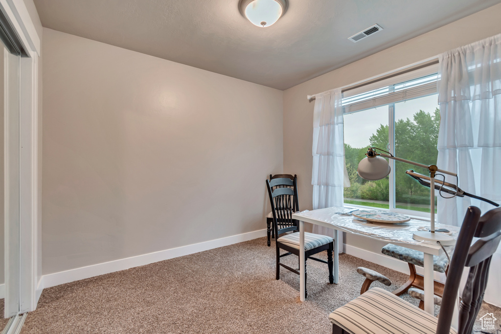 Carpeted home office featuring baseboards and visible vents