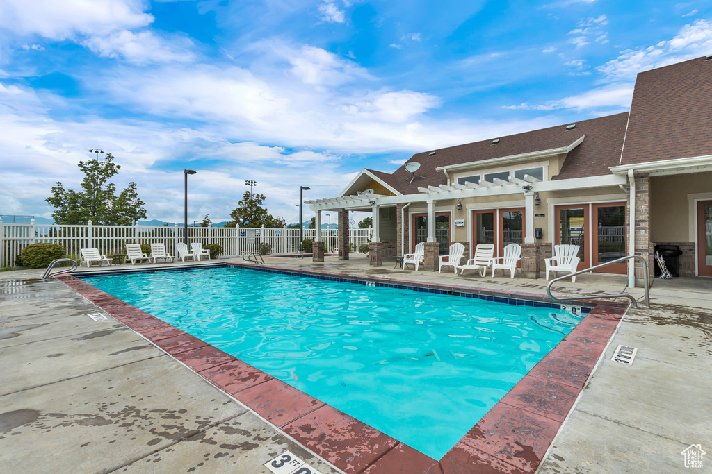 Community pool featuring a pergola, fence, and a patio