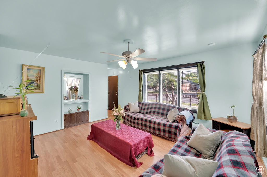 Living area featuring light wood-style flooring and ceiling fan