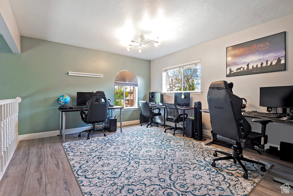 Home office featuring an inviting chandelier, a textured ceiling, wood finished floors, and baseboards