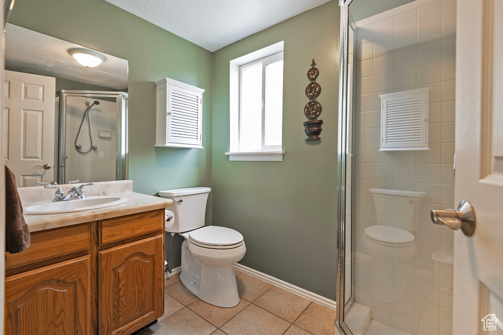 Full bath with baseboards, toilet, a shower stall, tile patterned floors, and vanity