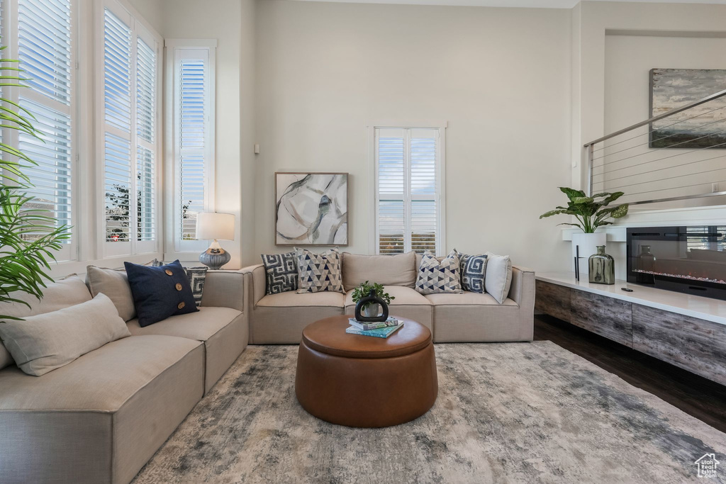 Living room with wood finished floors and a towering ceiling