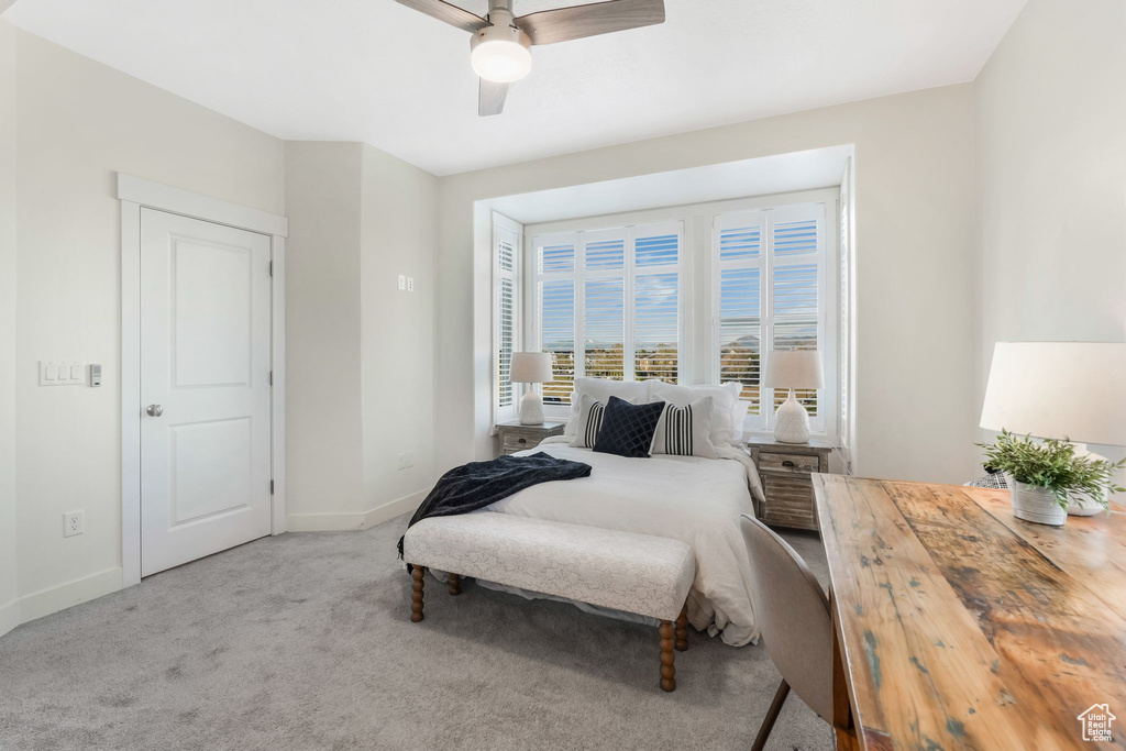 Carpeted bedroom featuring baseboards and ceiling fan