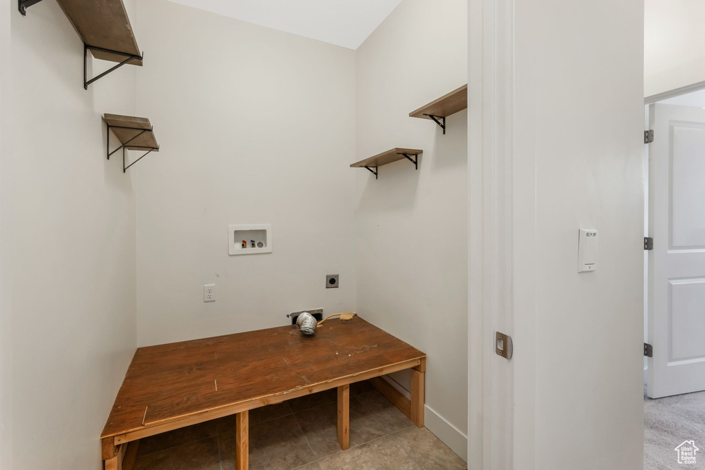 Laundry room with electric dryer hookup, washer hookup, baseboards, and light tile patterned floors