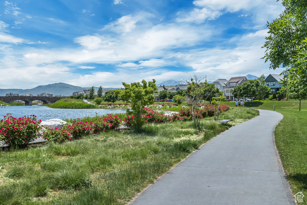 Surrounding community with a water and mountain view, a residential view, and a lawn