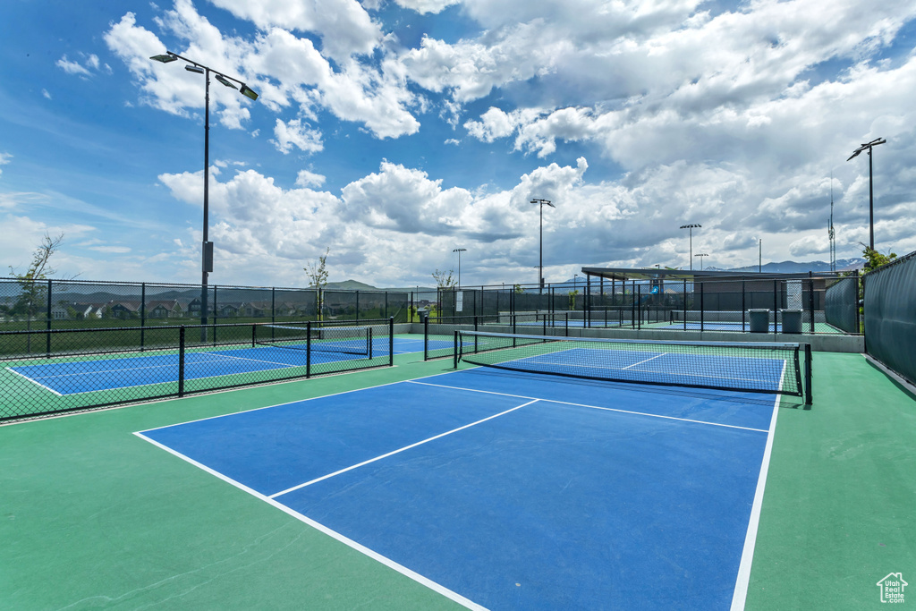 View of tennis court featuring fence
