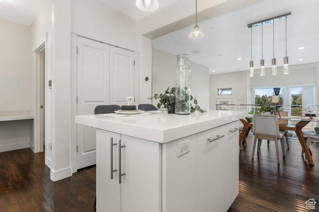Kitchen featuring dark wood finished floors, pendant lighting, light countertops, recessed lighting, and white cabinets