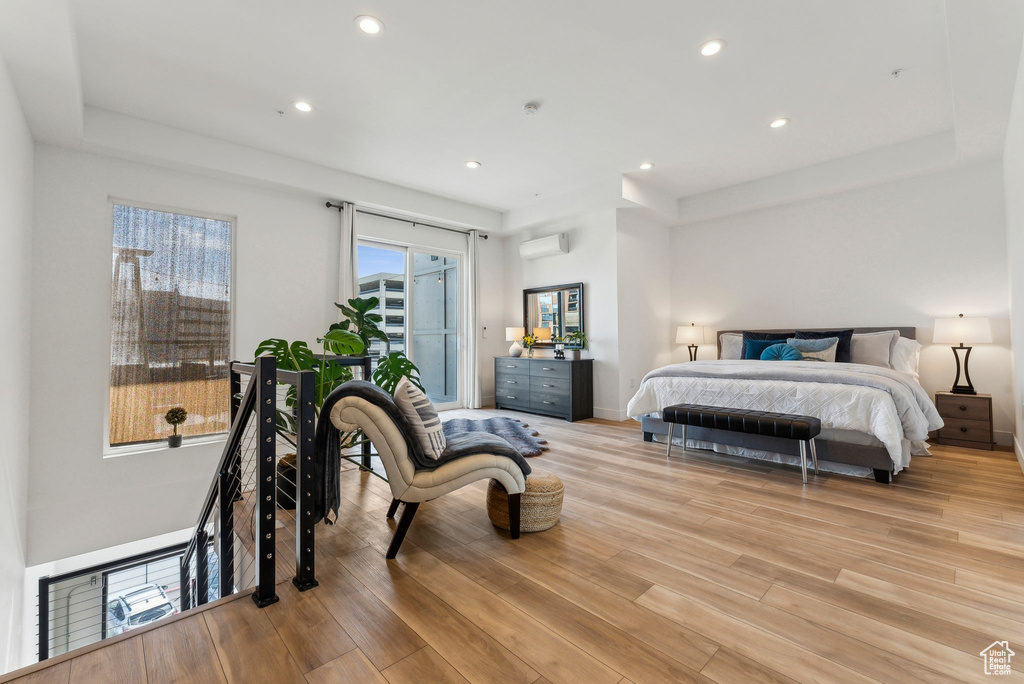 Bedroom featuring a wall mounted AC, access to outside, light wood finished floors, and recessed lighting
