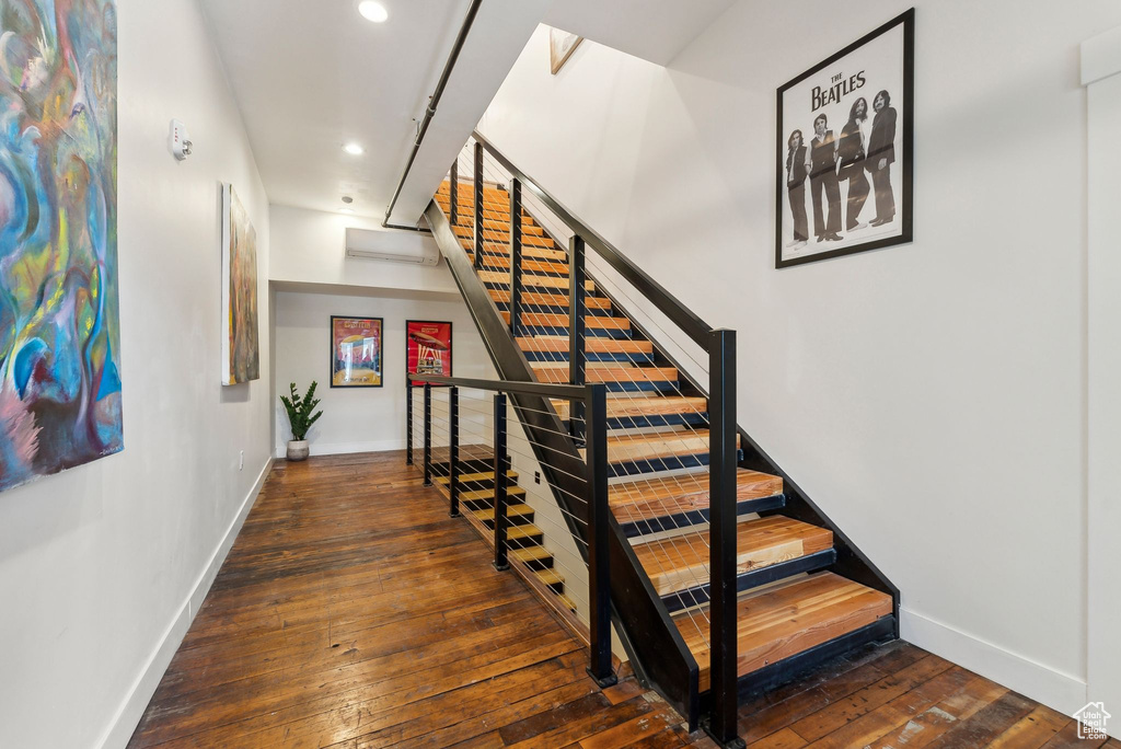 Stairs featuring baseboards, recessed lighting, hardwood / wood-style floors, and a wall mounted air conditioner