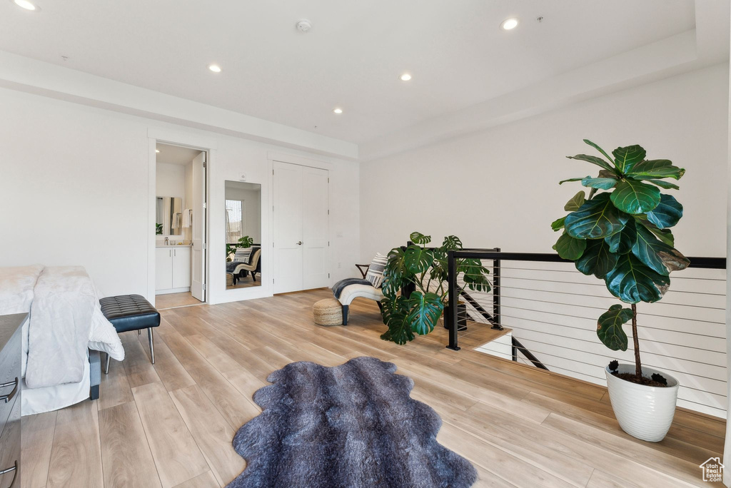 Living area featuring light wood-style flooring, an upstairs landing, and recessed lighting