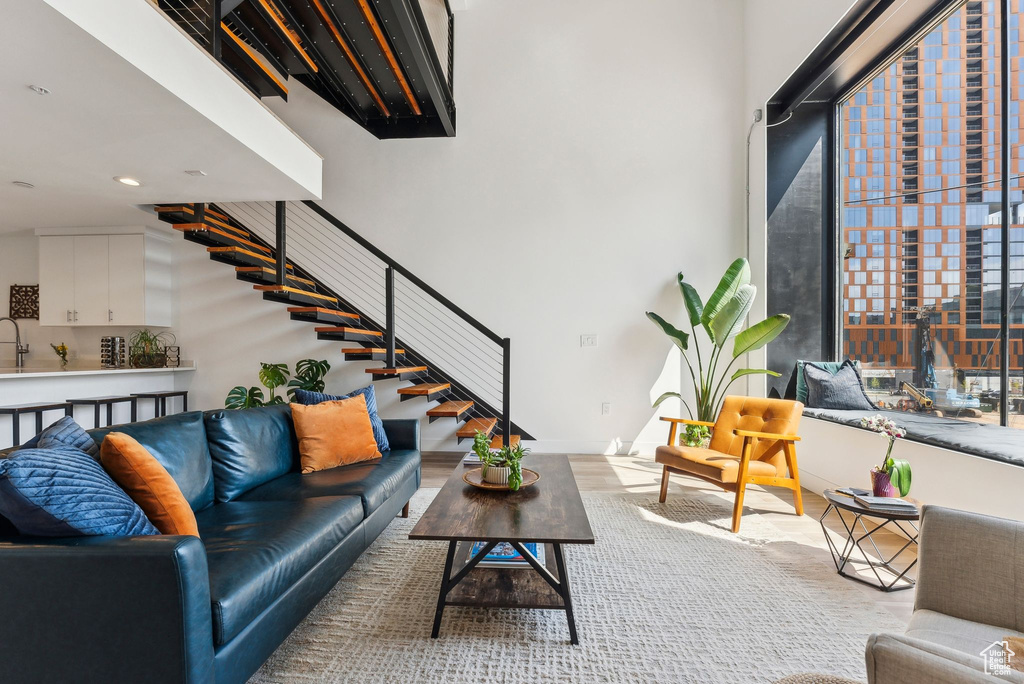 Living area with stairs, recessed lighting, and wood finished floors