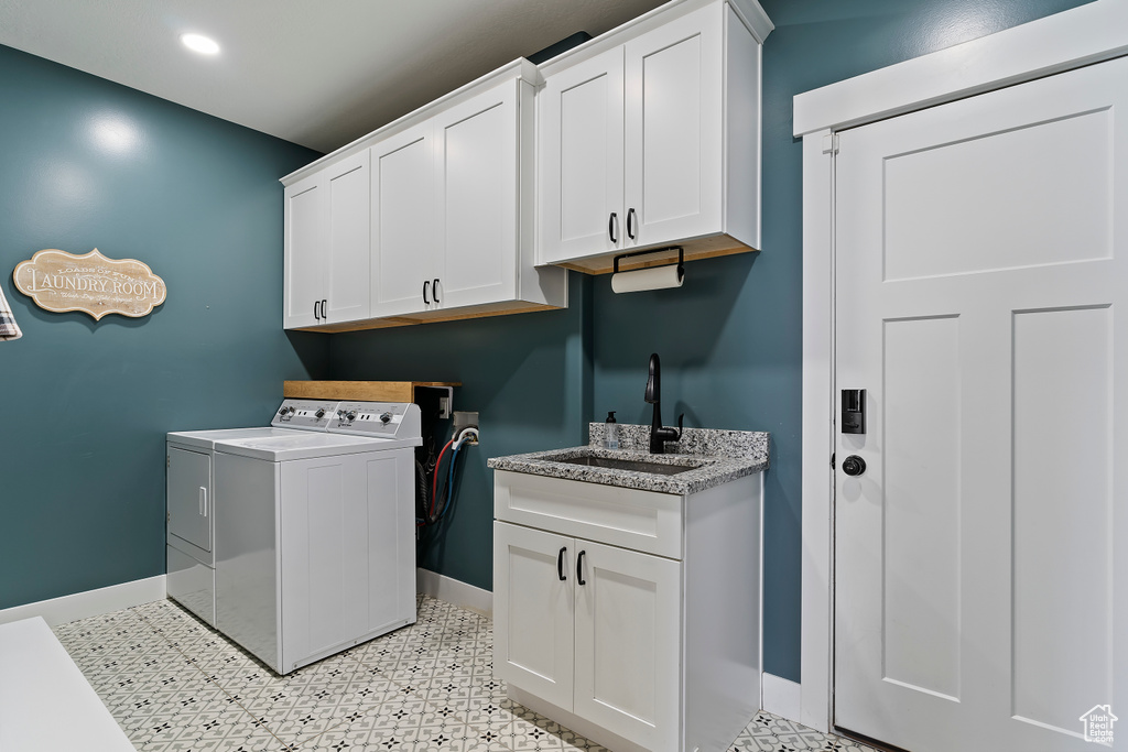 Laundry area featuring separate washer and dryer, baseboards, cabinet space, light flooring, and recessed lighting
