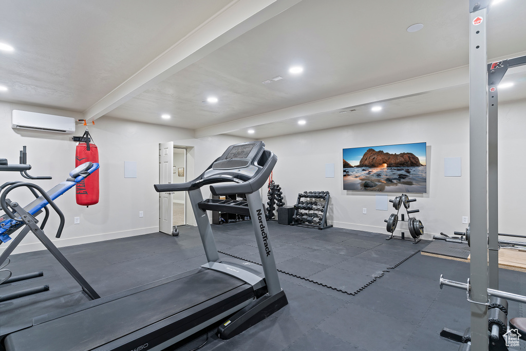 Workout room featuring a wall unit AC, recessed lighting, and baseboards