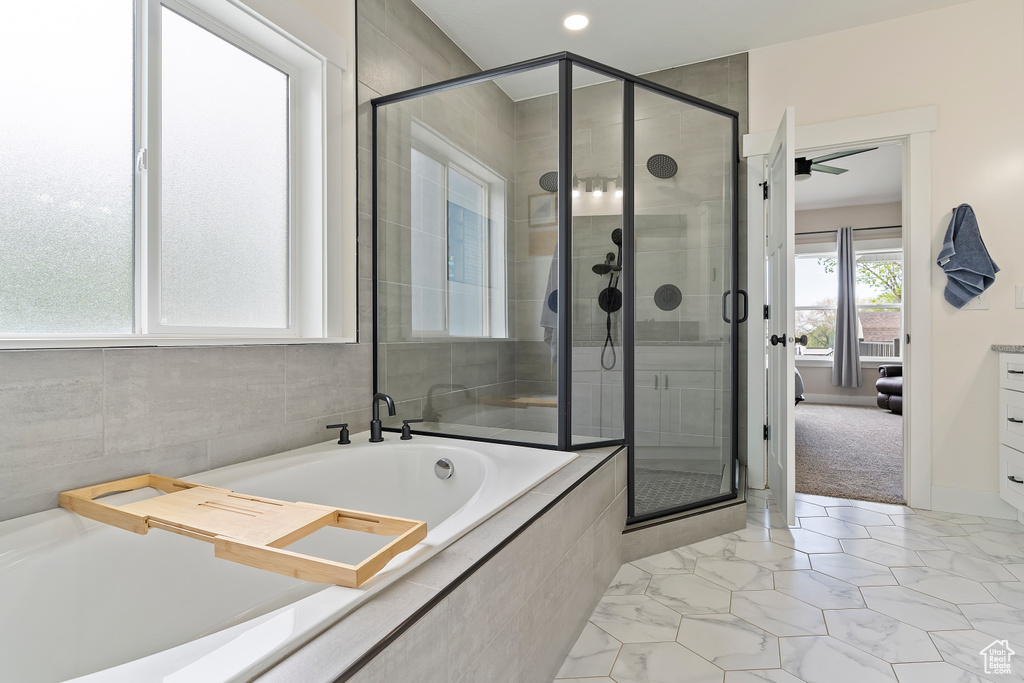 Full bathroom with a stall shower, a garden tub, marble look tile flooring, and recessed lighting