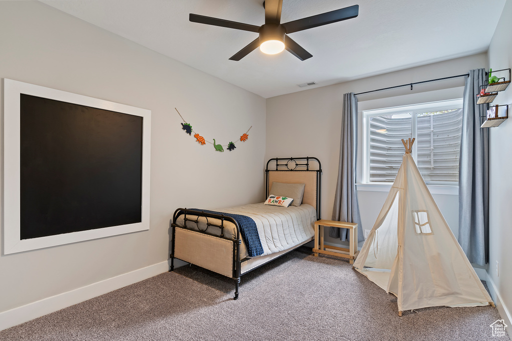 Carpeted bedroom with baseboards and a ceiling fan