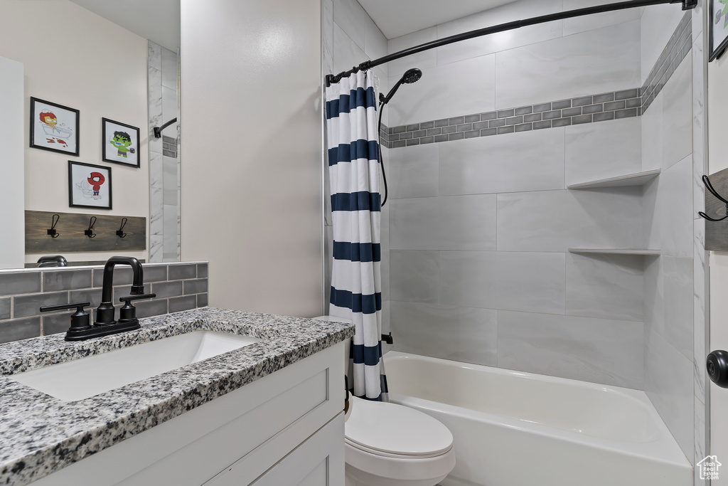 Full bath featuring shower / bath combo, toilet, and vanity