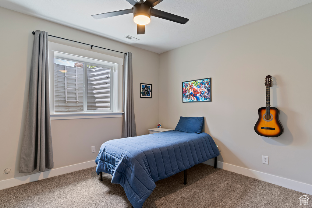 Carpeted bedroom with baseboards and ceiling fan