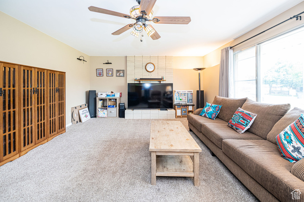 Living room with carpet, ceiling fan, and baseboards