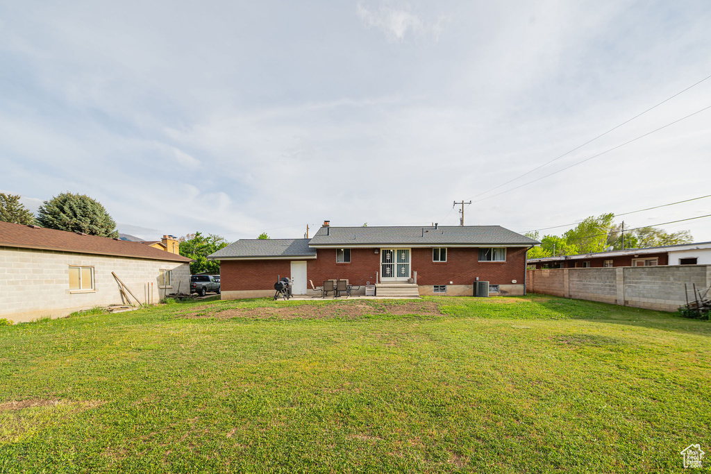 Back of house featuring entry steps, brick siding, a patio area, and cooling unit