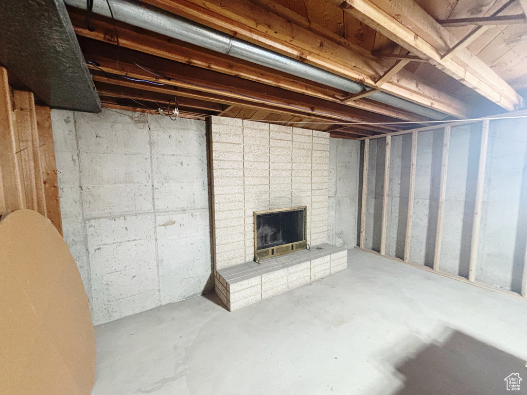 Unfinished basement with a brick fireplace