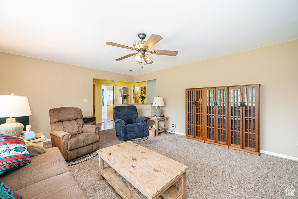 Living room with ceiling fan, carpet floors, and baseboards