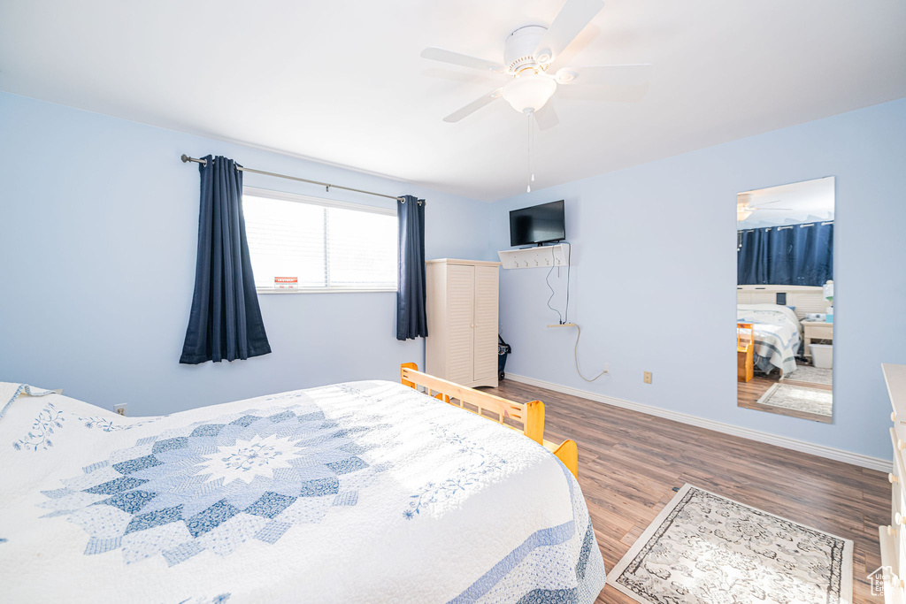Bedroom featuring wood finished floors, baseboards, and a ceiling fan