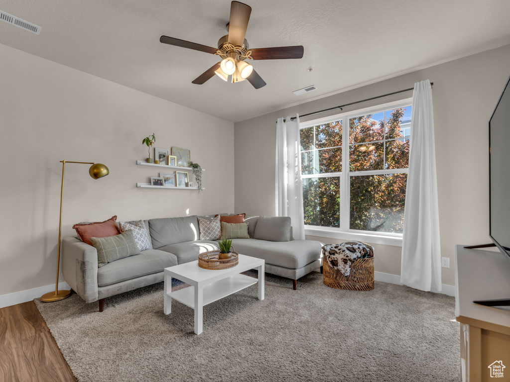 Living room featuring a ceiling fan and baseboards