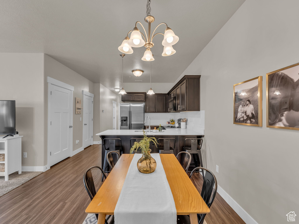 Dining area featuring a chandelier, wood finished floors, and baseboards