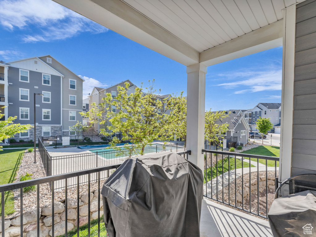 Balcony featuring view of pool area, area for grilling, and a residential view