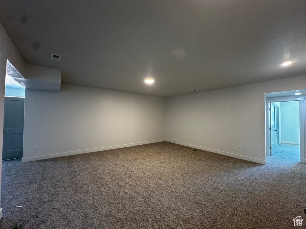 Carpeted empty room with baseboards and recessed lighting