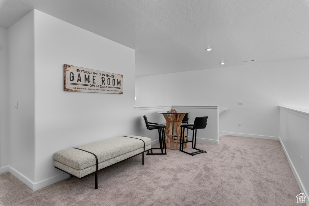 Living area featuring an upstairs landing, carpet floors, baseboards, and recessed lighting