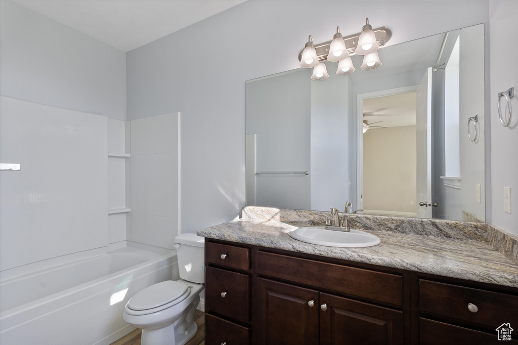 Bathroom with toilet, vanity, ceiling fan, and shower / bathtub combination