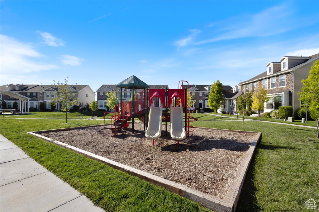 Community play area with a residential view and a lawn