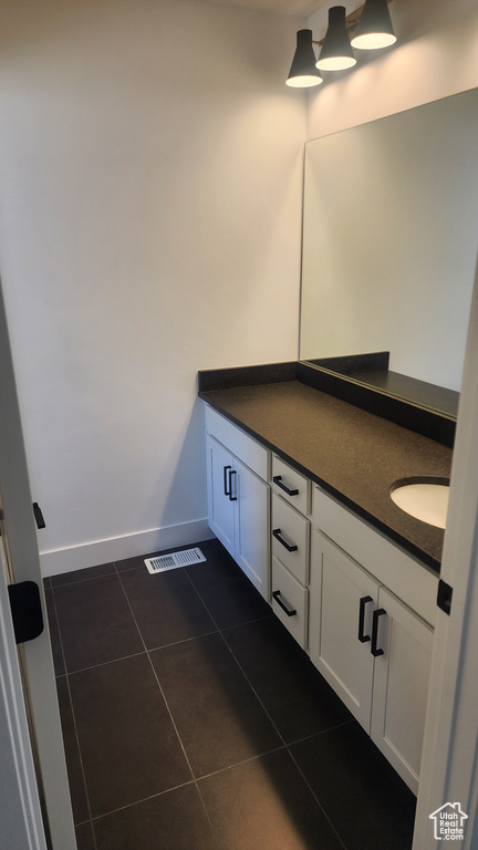 Bathroom featuring tile patterned flooring, vanity, and baseboards