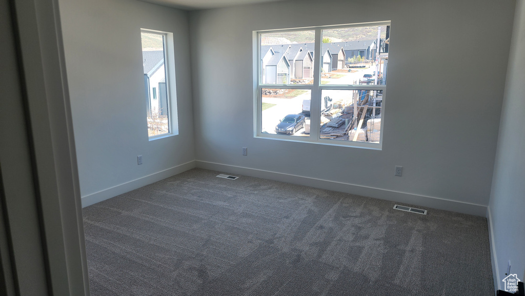 Empty room featuring carpet and baseboards