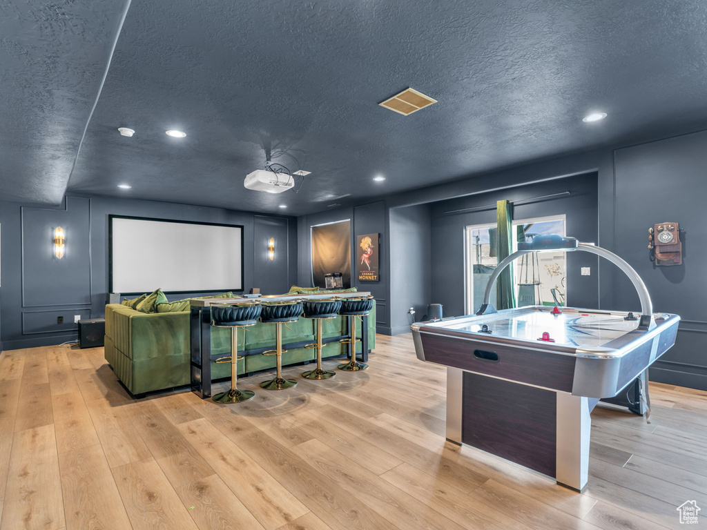 Cinema featuring a textured ceiling, recessed lighting, and wood finished floors