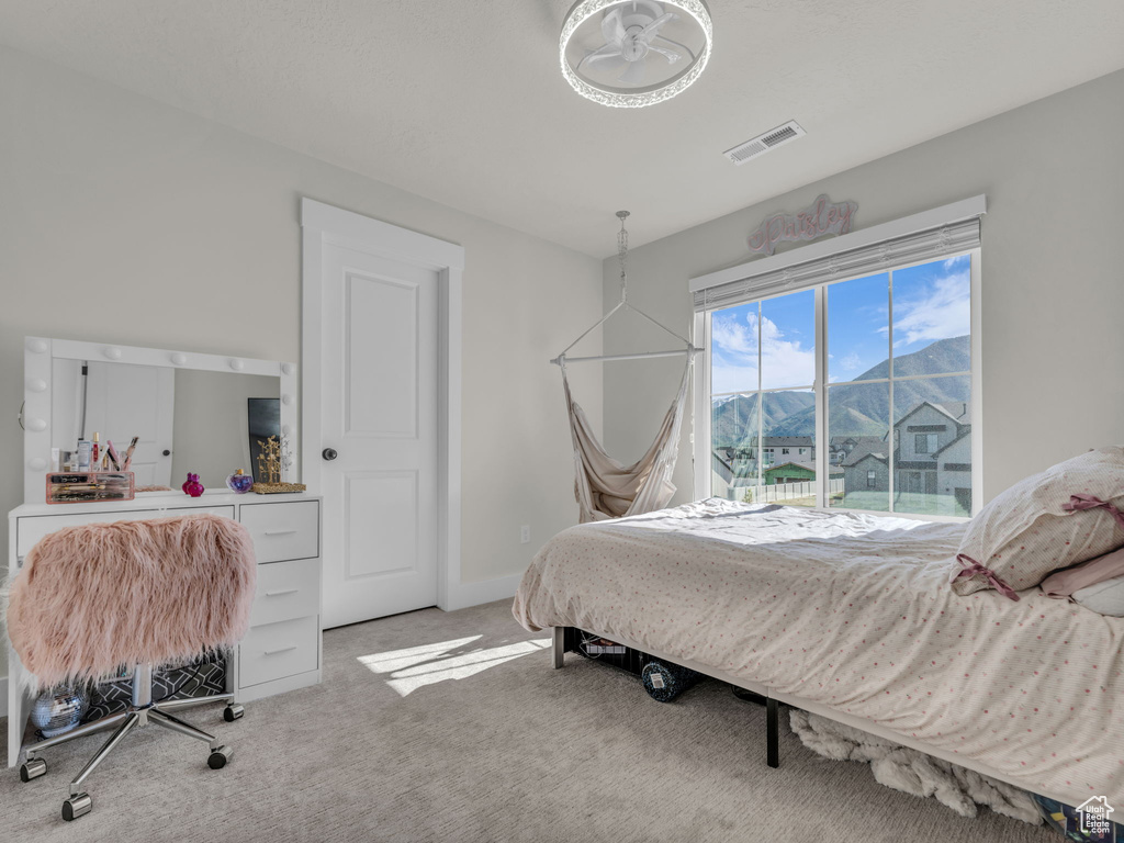 Bedroom with light colored carpet, a mountain view, and baseboards