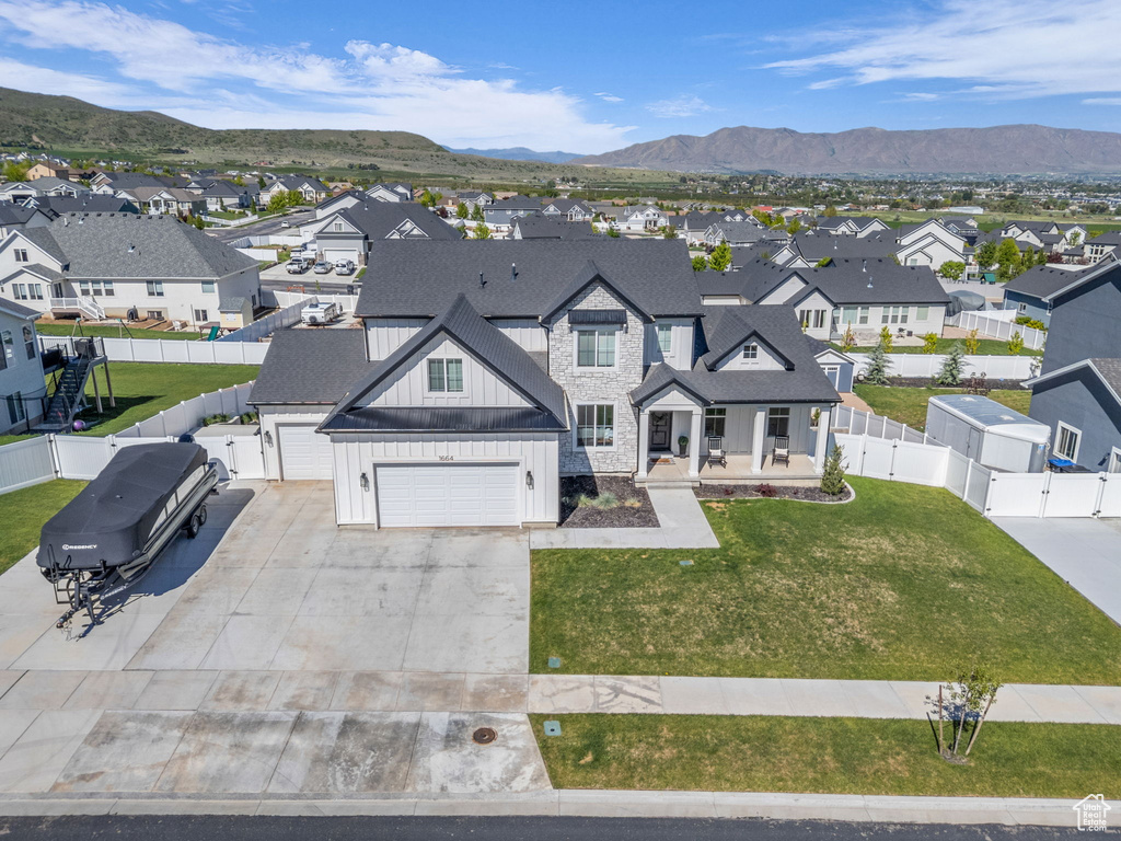 View of front of home with board and batten siding, a residential view, a gate, concrete driveway, and covered porch