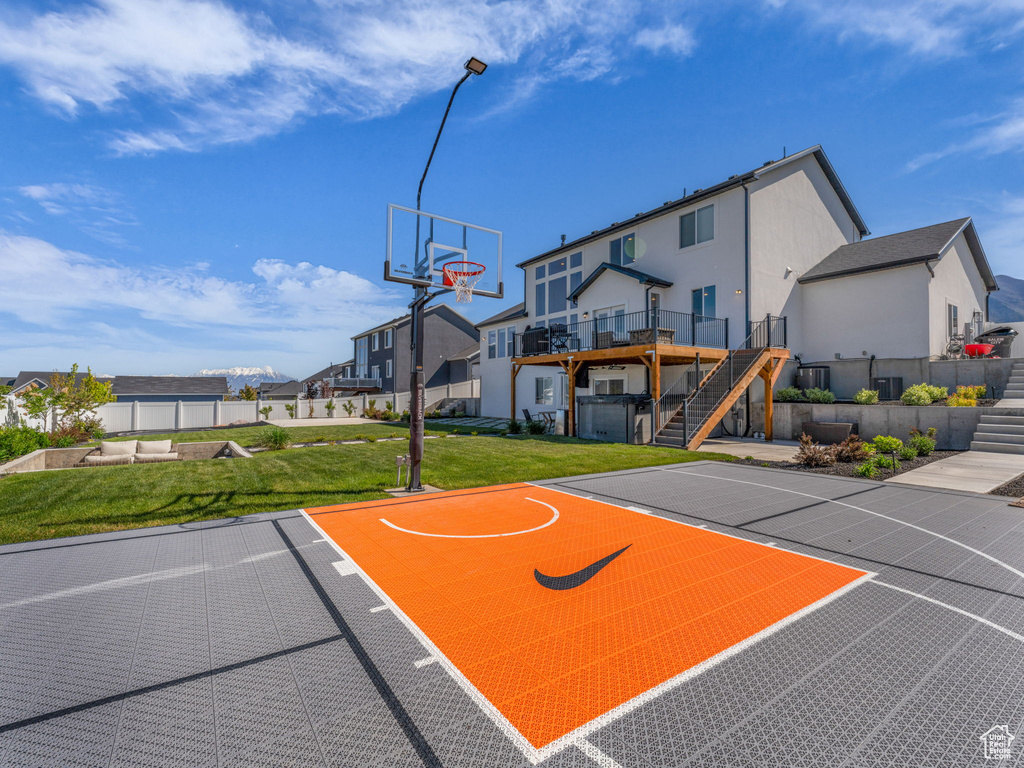 View of sport court featuring basketball court, stairs, and a residential view
