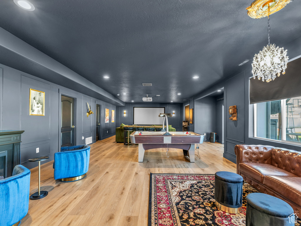 Rec room with pool table, light wood-type flooring, a chandelier, recessed lighting, and a decorative wall