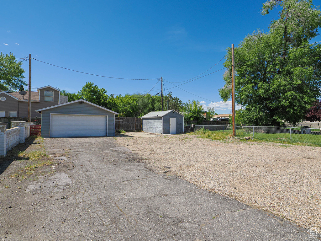View of yard with a garage, an outdoor structure, and fence