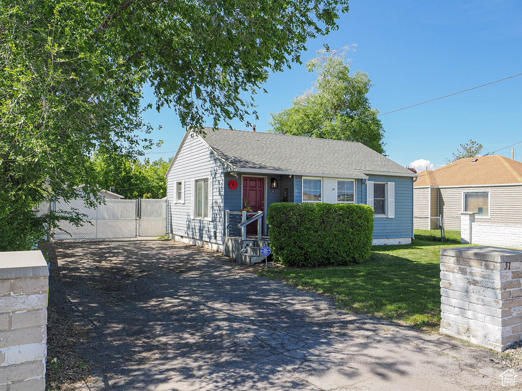 View of front facade with driveway and roof with shingles