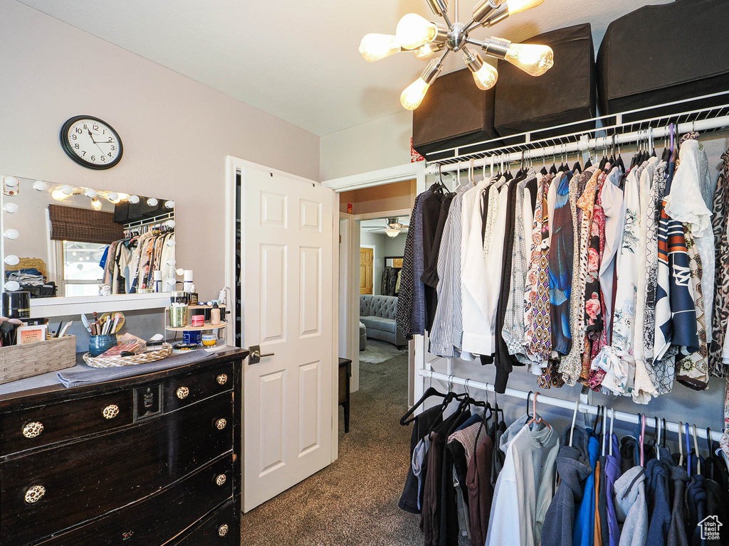 Spacious closet with carpet and a chandelier