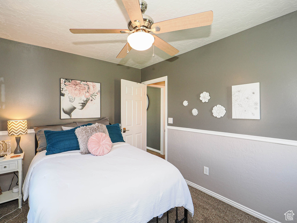 Carpeted bedroom featuring a ceiling fan and baseboards