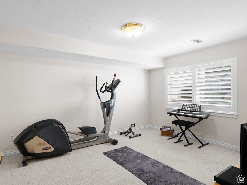 Exercise room with carpet floors and baseboards
