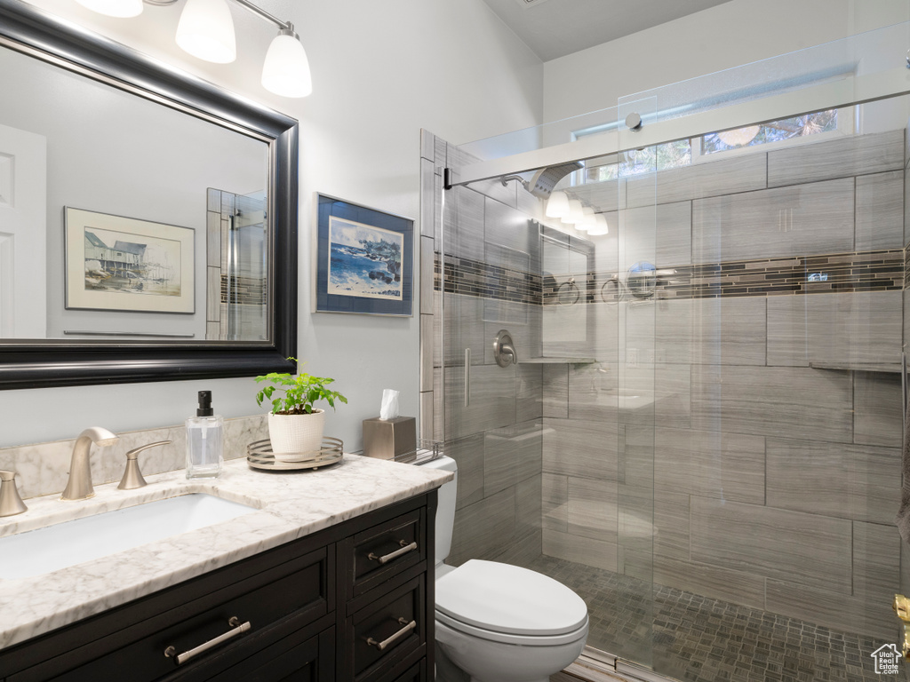 Full bath with toilet, a shower stall, and vanity