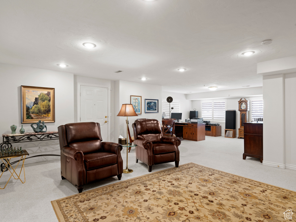 Living area featuring light carpet, a desk, and recessed lighting