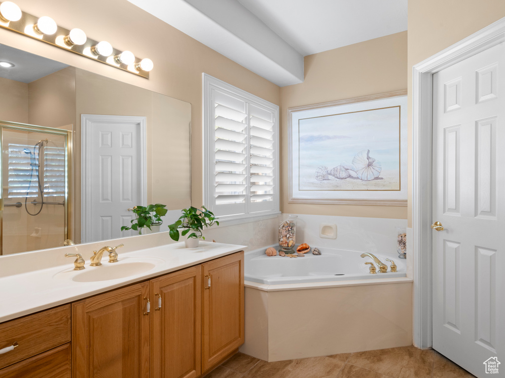 Bathroom with a shower stall, vanity, a bath, and tile patterned flooring
