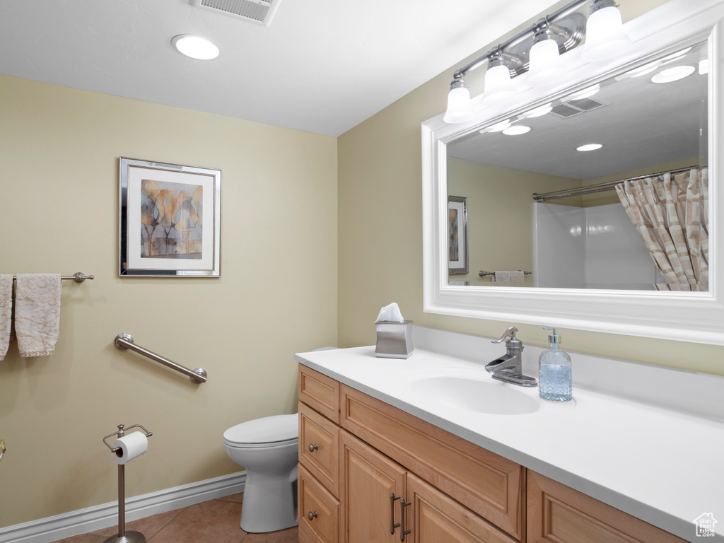 Full bathroom with tile patterned floors, vanity, toilet, curtained shower, and baseboards