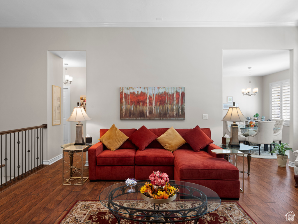 Living area with a chandelier, hardwood / wood-style floors, crown molding, and baseboards